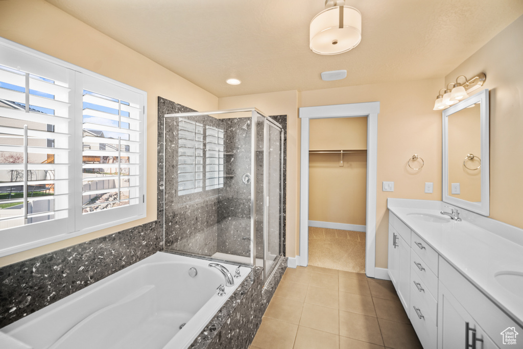 Bathroom featuring tile flooring, plenty of natural light, and shower with separate bathtub