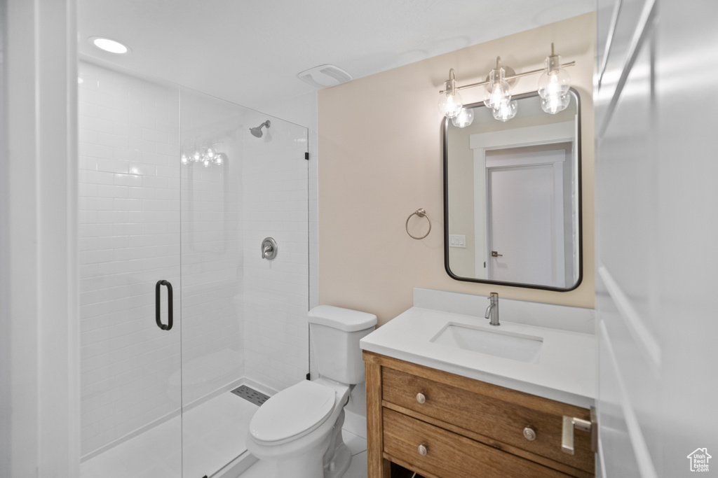 Bathroom with a shower with shower door, toilet, and oversized vanity