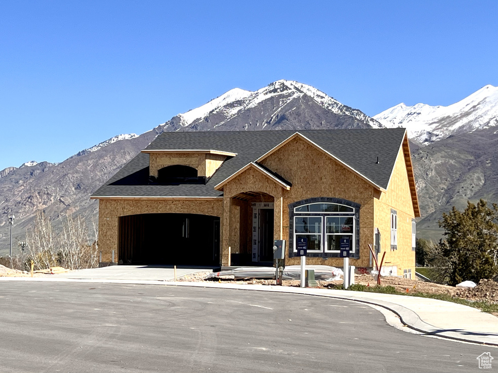 View of front of home with a mountain view and a garage