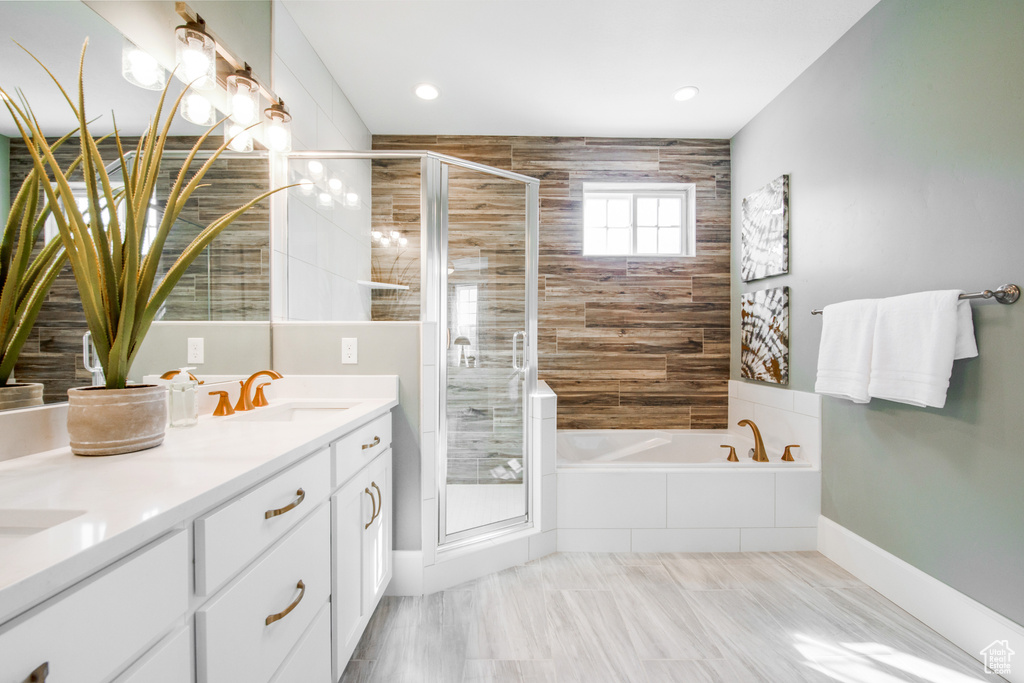 Bathroom featuring tile flooring, dual vanity, and plus walk in shower