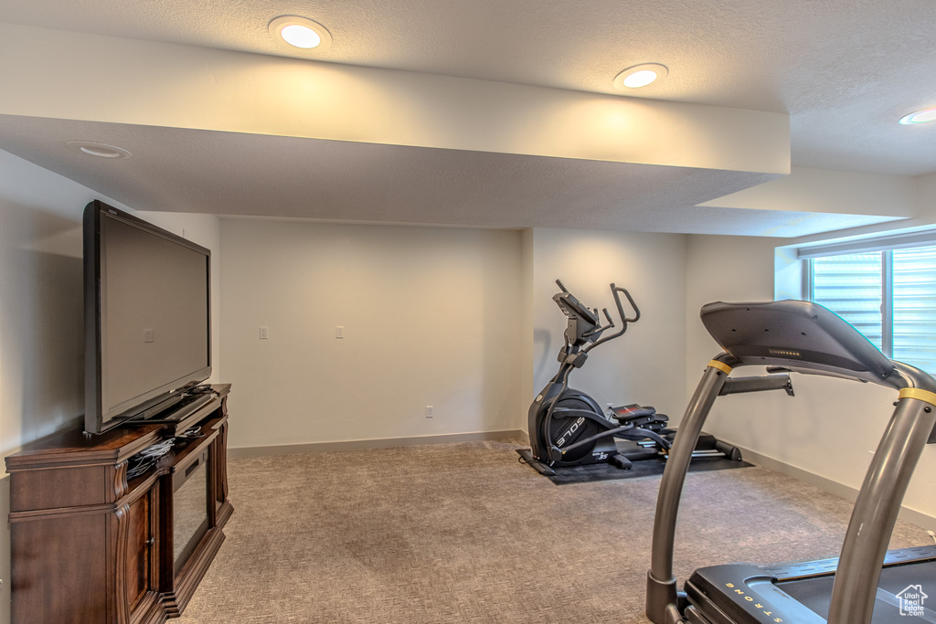 Workout area with carpet floors and a textured ceiling
