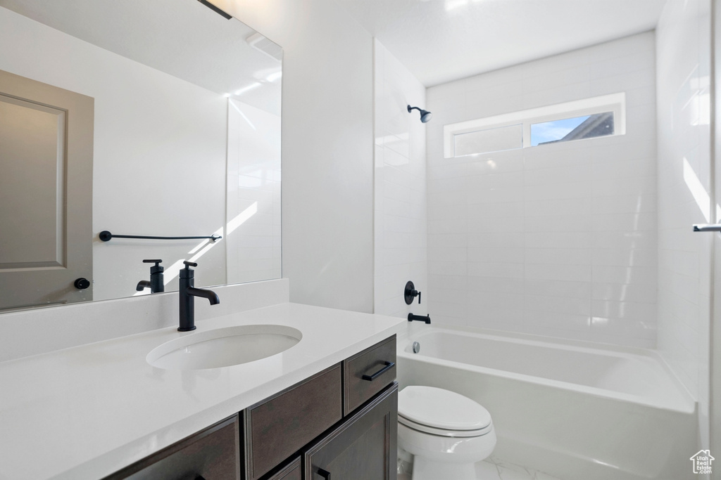 Full bathroom with washtub / shower combination, toilet, and vanity with extensive cabinet space