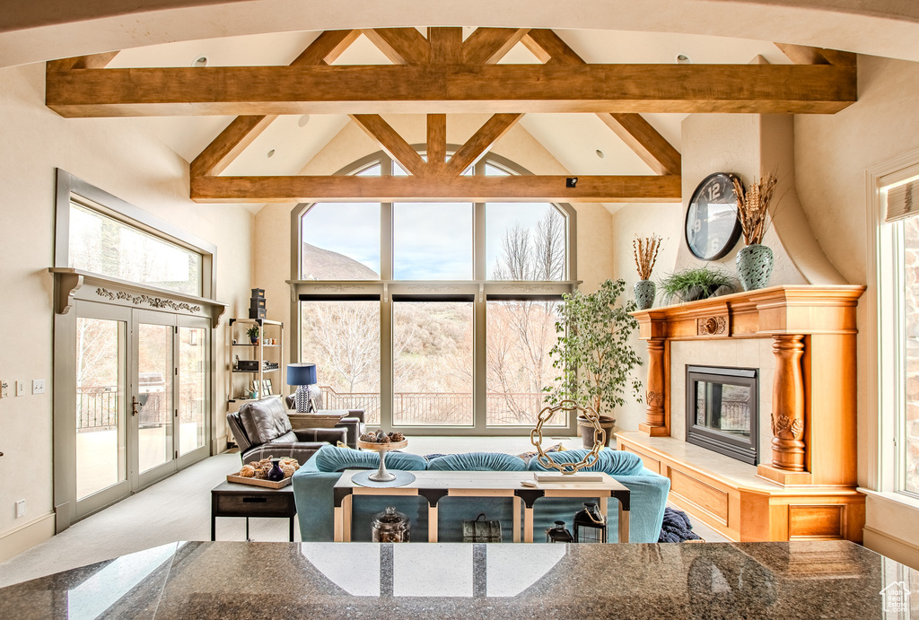 Carpeted living room featuring high vaulted ceiling, beam ceiling, a healthy amount of sunlight, and french doors