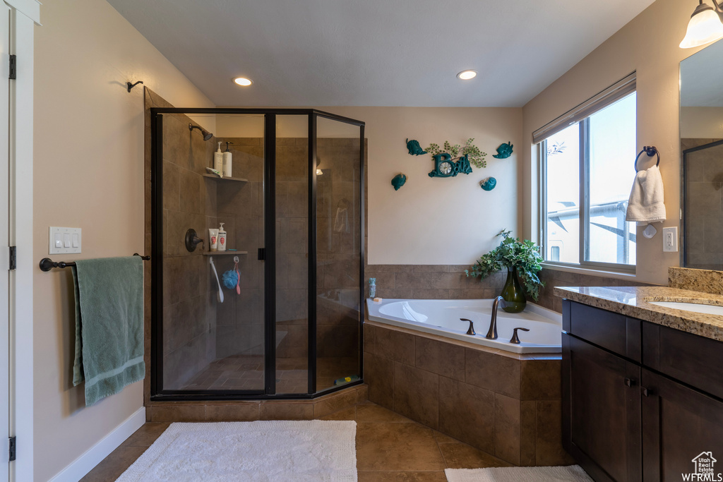 Bathroom featuring vanity, tile floors, and separate shower and tub