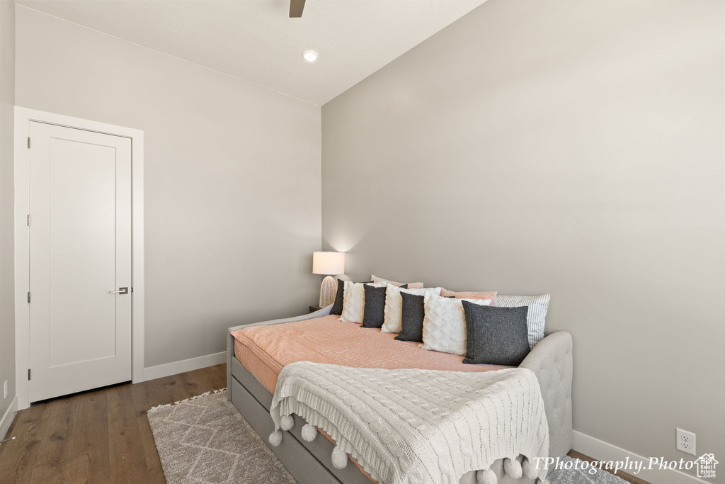 Bedroom featuring ceiling fan, dark hardwood / wood-style floors, and vaulted ceiling