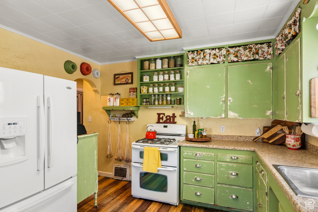 Kitchen with white appliances, crown molding, dark wood-type flooring, green cabinets, and sink