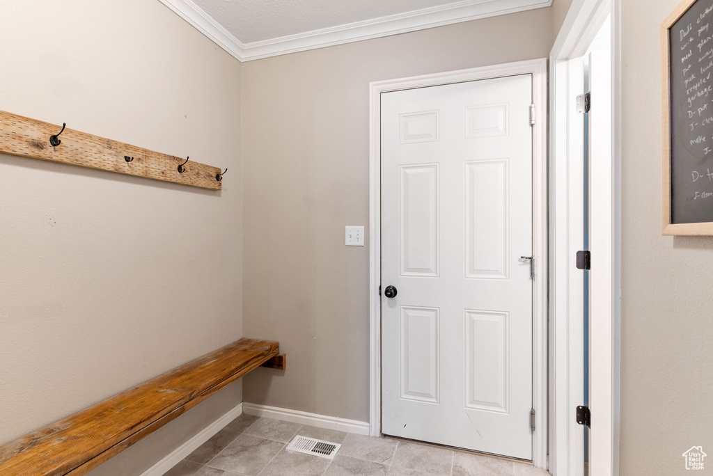 Mudroom featuring crown molding and light tile flooring