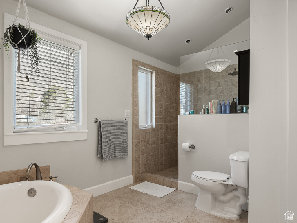 Bathroom featuring plus walk in shower, a wealth of natural light, tile floors, and toilet