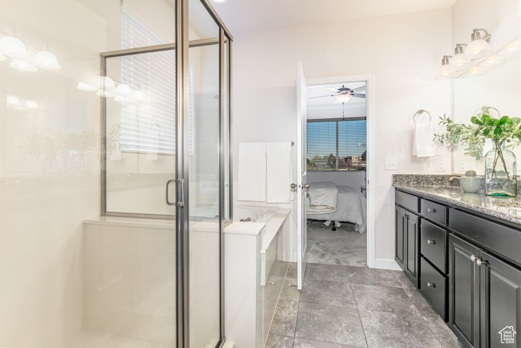 Bathroom featuring vanity, a shower with shower door, tile flooring, and ceiling fan