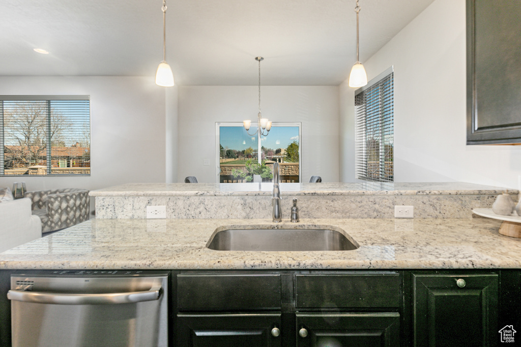 Kitchen featuring sink, a wealth of natural light, dishwasher, and decorative light fixtures
