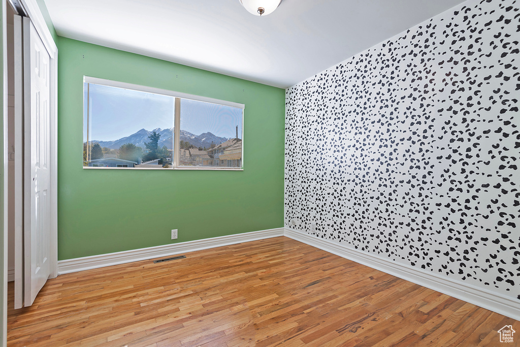 Spare room with a mountain view and light hardwood / wood-style floors