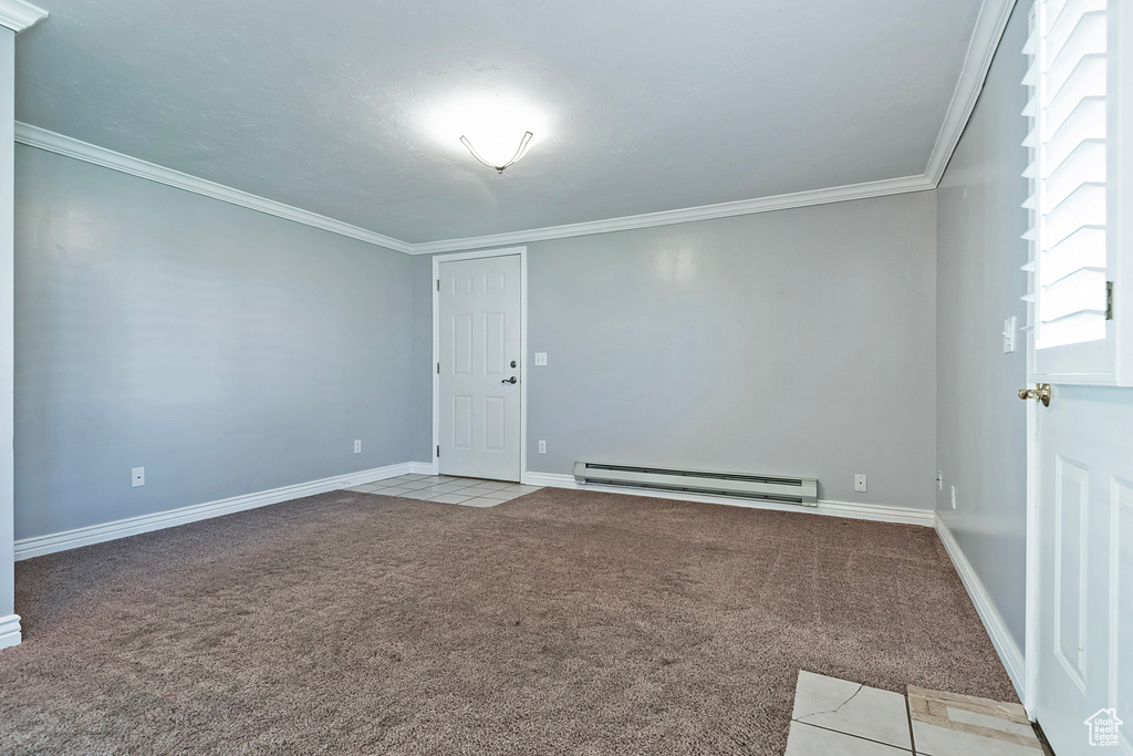 Spare room with ornamental molding, a baseboard heating unit, and light carpet
