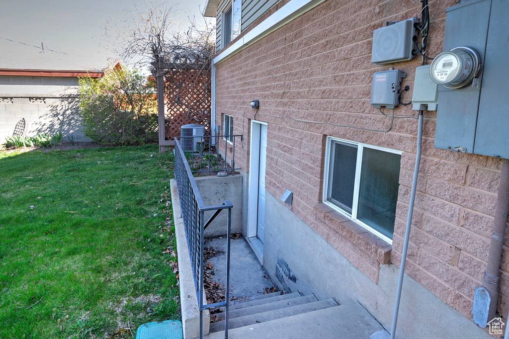 View of side of property featuring a yard and central air condition unit