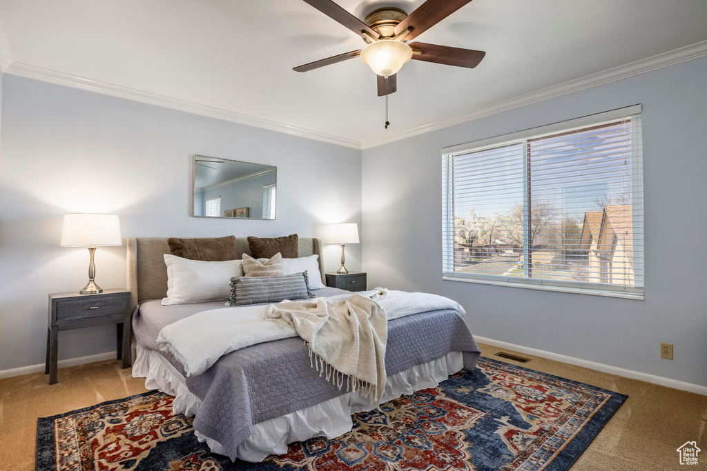 Bedroom featuring light carpet, ceiling fan, and crown molding