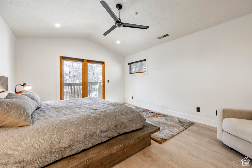 Bedroom with lofted ceiling, ceiling fan, light wood-type flooring, and access to exterior