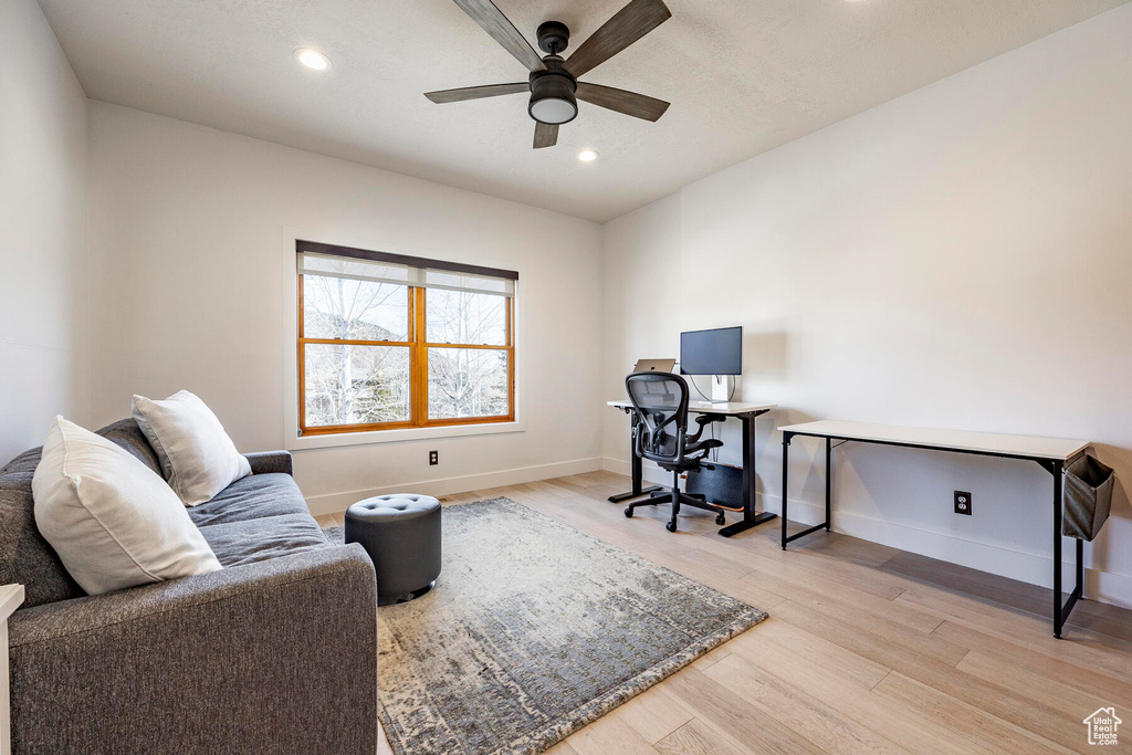 Office with light hardwood / wood-style floors and ceiling fan