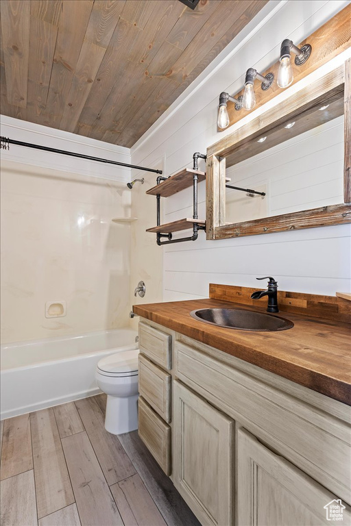 Full bathroom featuring wood-type flooring, vanity, bathtub / shower combination, wood ceiling, and toilet
