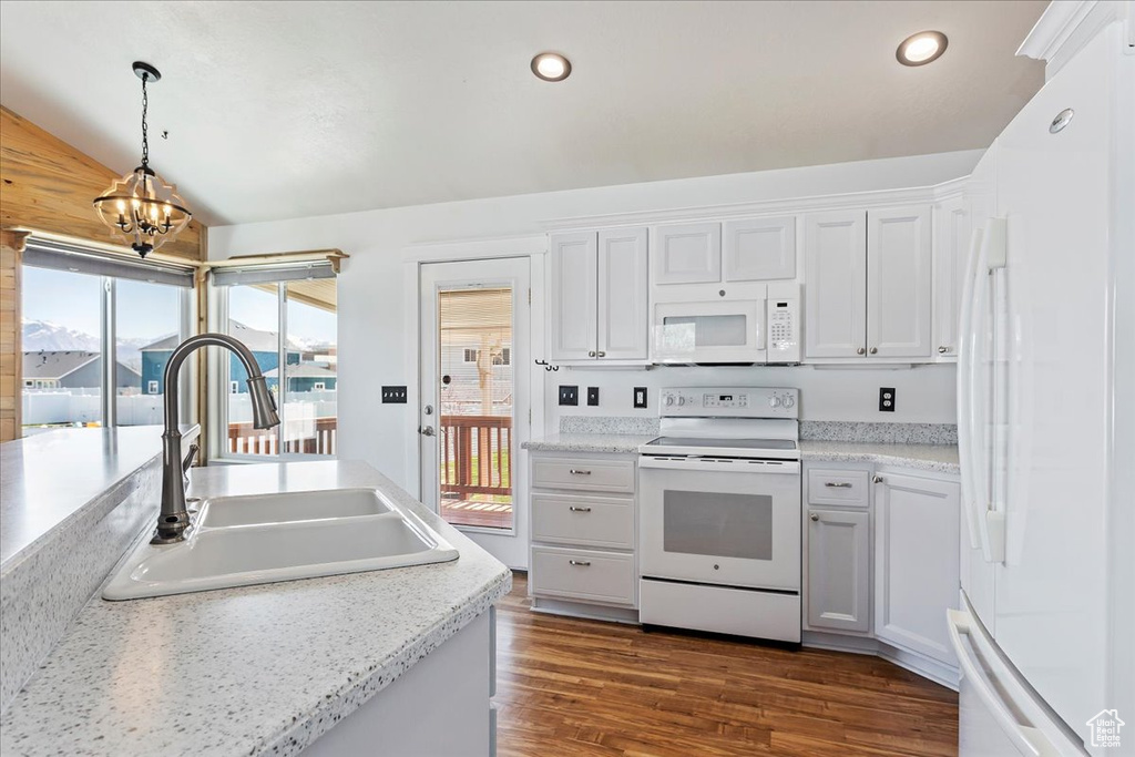 Kitchen featuring pendant lighting, white cabinets, and white appliances