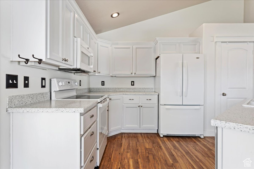 Kitchen featuring white cabinets, white appliances, light stone countertops, dark hardwood / wood-style flooring, and lofted ceiling