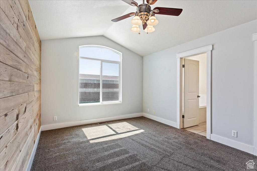 Empty room with light colored carpet, ceiling fan, and lofted ceiling
