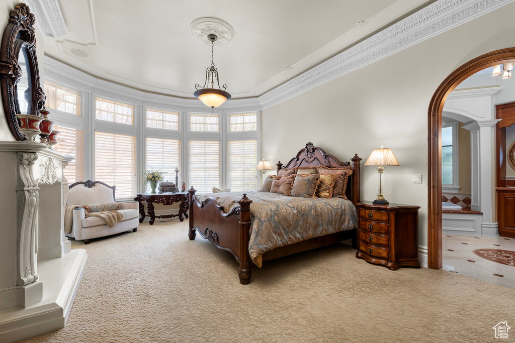 Carpeted bedroom featuring crown molding and decorative columns