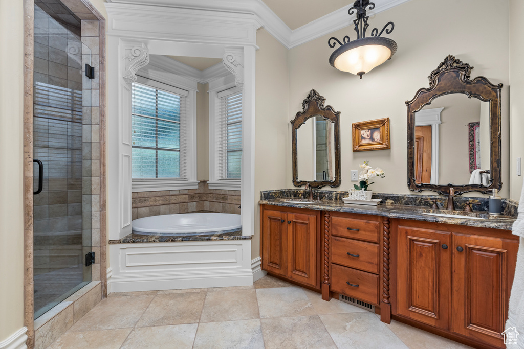 Bathroom featuring dual sinks, shower with separate bathtub, tile floors, and large vanity