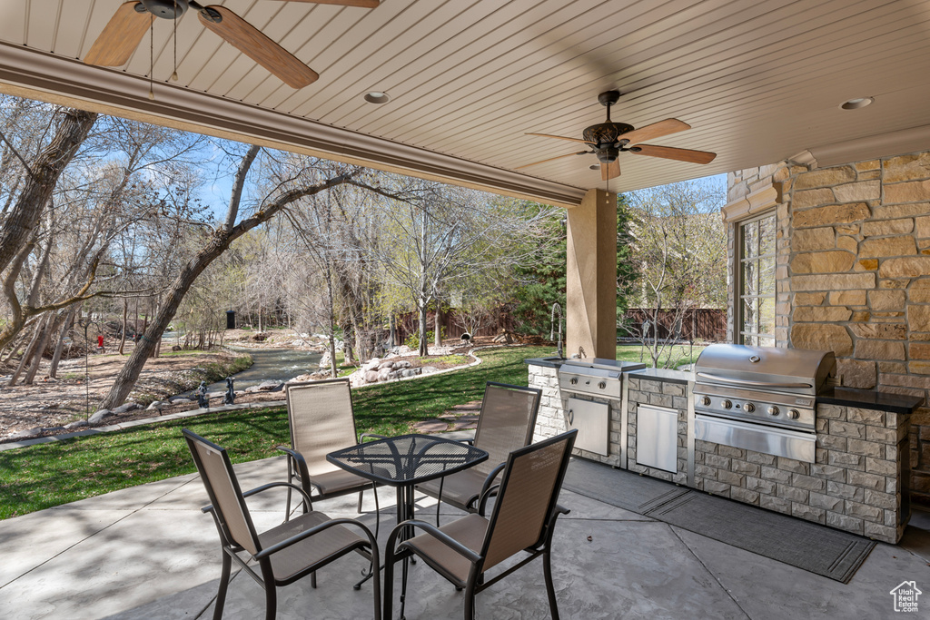 View of terrace with area for grilling and ceiling fan