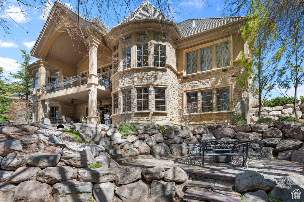 Back of property featuring a balcony and a patio