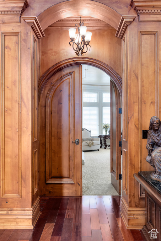 Foyer entrance featuring dark colored carpet and a chandelier