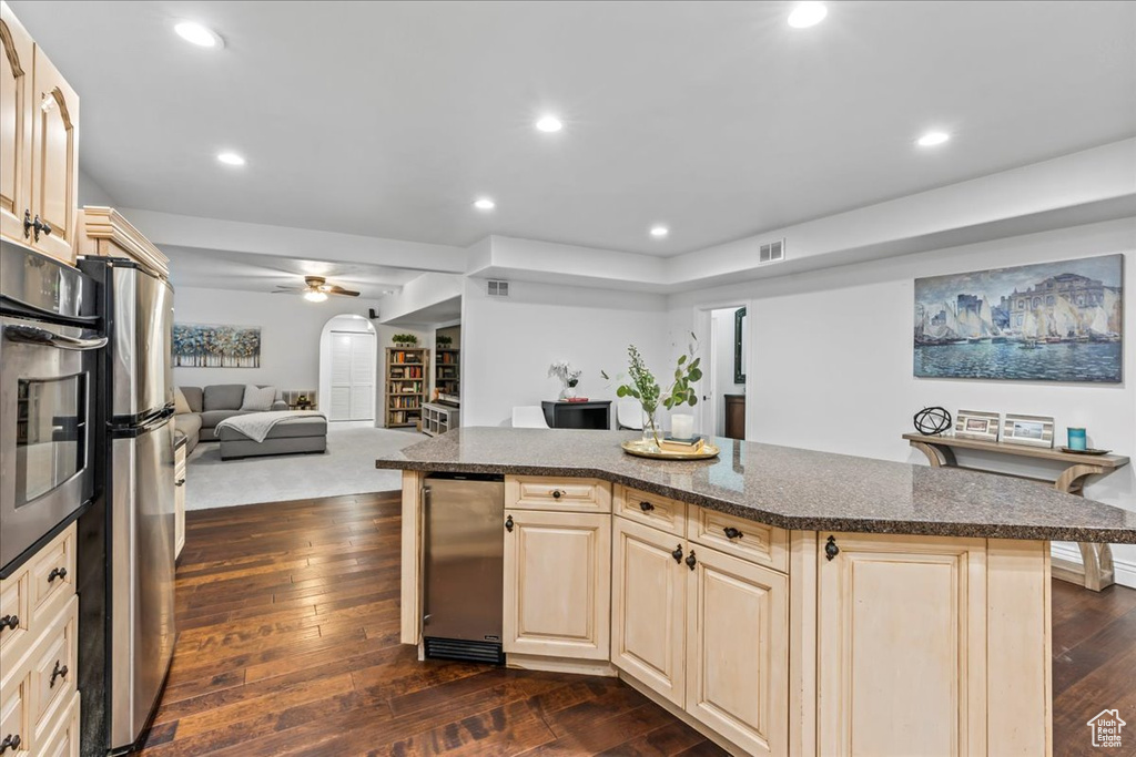 Kitchen with dark carpet, ceiling fan, a center island, and appliances with stainless steel finishes