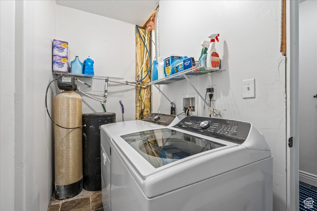 Clothes washing area with washer hookup, dark tile flooring, and washing machine and clothes dryer