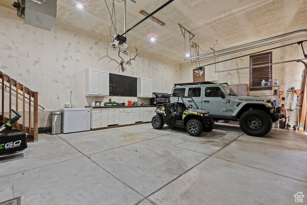 Garage featuring a workshop area and fridge