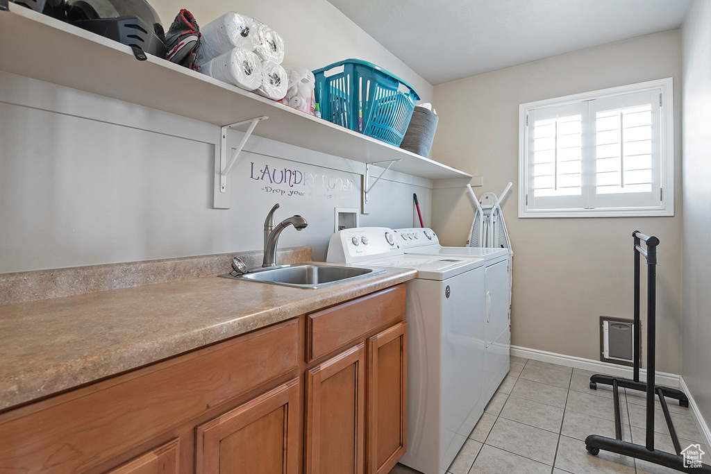 Laundry room featuring washing machine and clothes dryer, light tile flooring, sink, cabinets, and hookup for a washing machine
