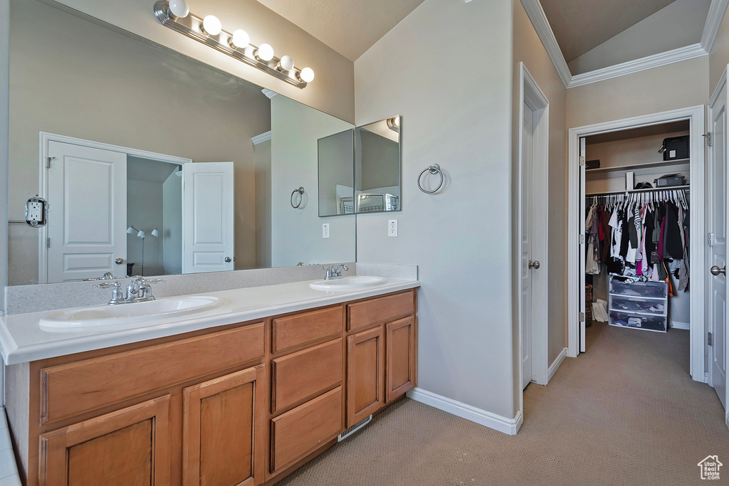Bathroom featuring double vanity and vaulted ceiling