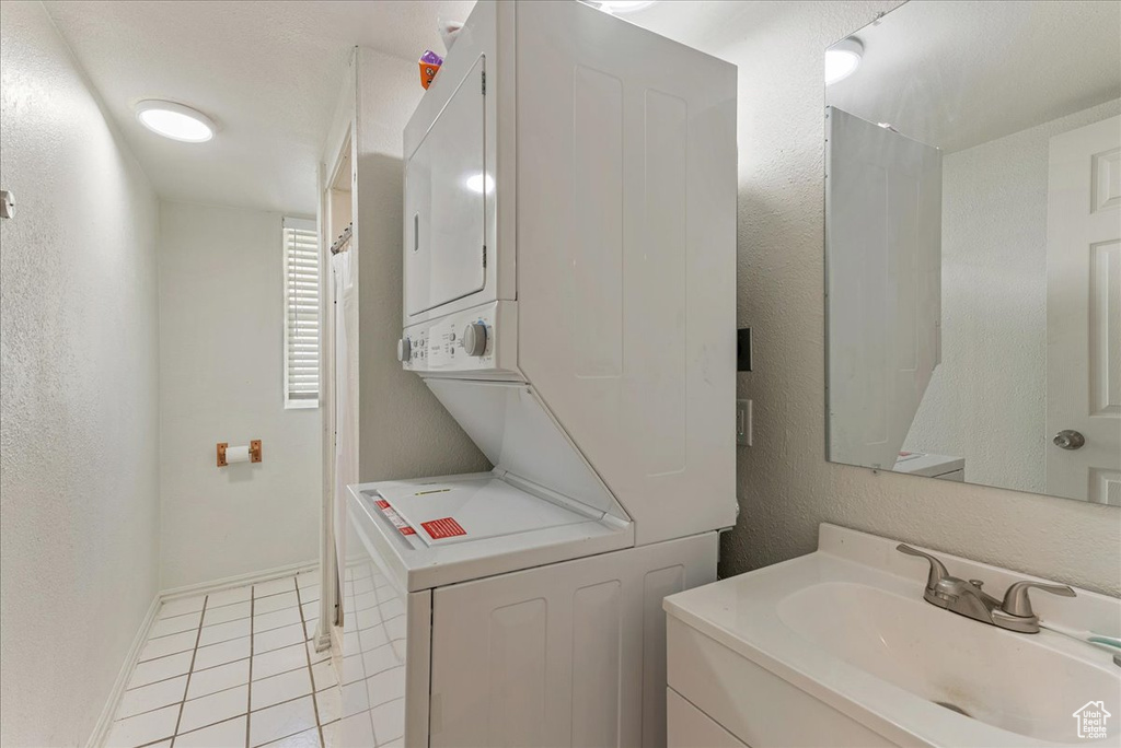 Bathroom with vanity, stacked washer and dryer, and tile flooring