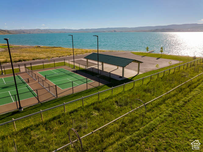 Exterior space with tennis court and a water view