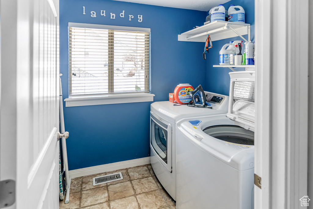 Laundry room with independent washer and dryer and light tile floors