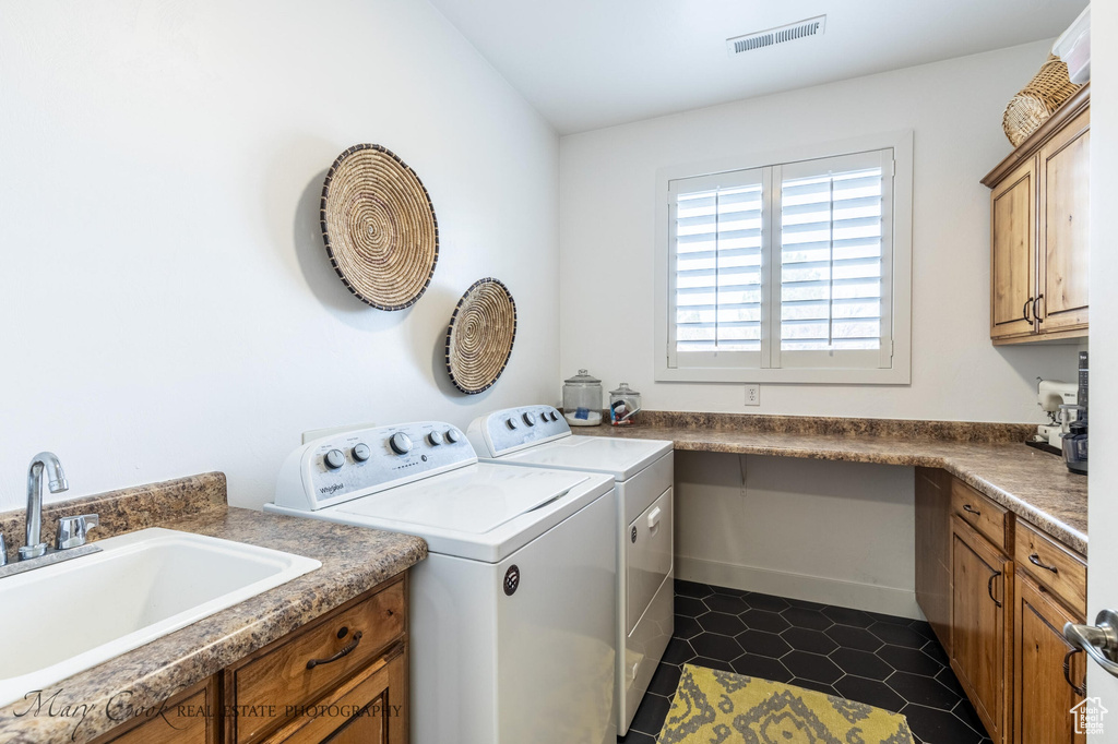 Laundry area with cabinets, dark tile flooring, sink, and washer and clothes dryer