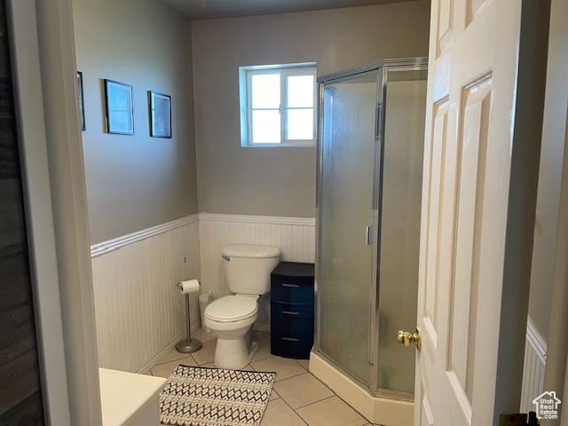 Bathroom with a shower with door, toilet, tile flooring, and vanity