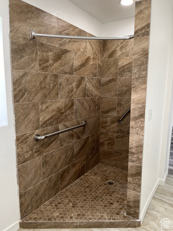 Bathroom featuring tiled shower and hardwood / wood-style flooring