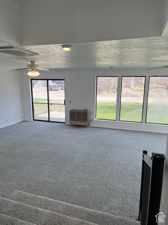 Unfurnished room with carpet, ceiling fan, and a textured ceiling