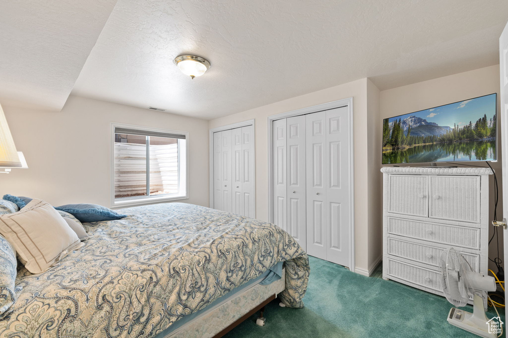 Bedroom featuring two closets and dark carpet