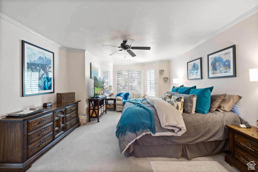 Bedroom featuring light colored carpet, ceiling fan, and crown molding