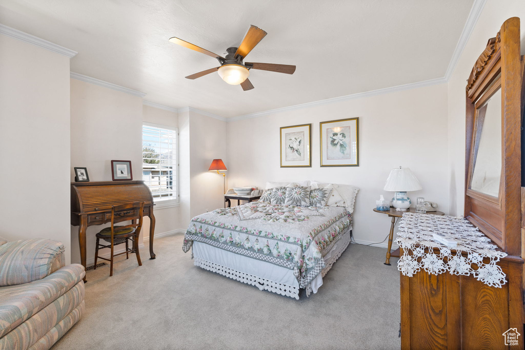 Bedroom with ceiling fan, light carpet, and ornamental molding