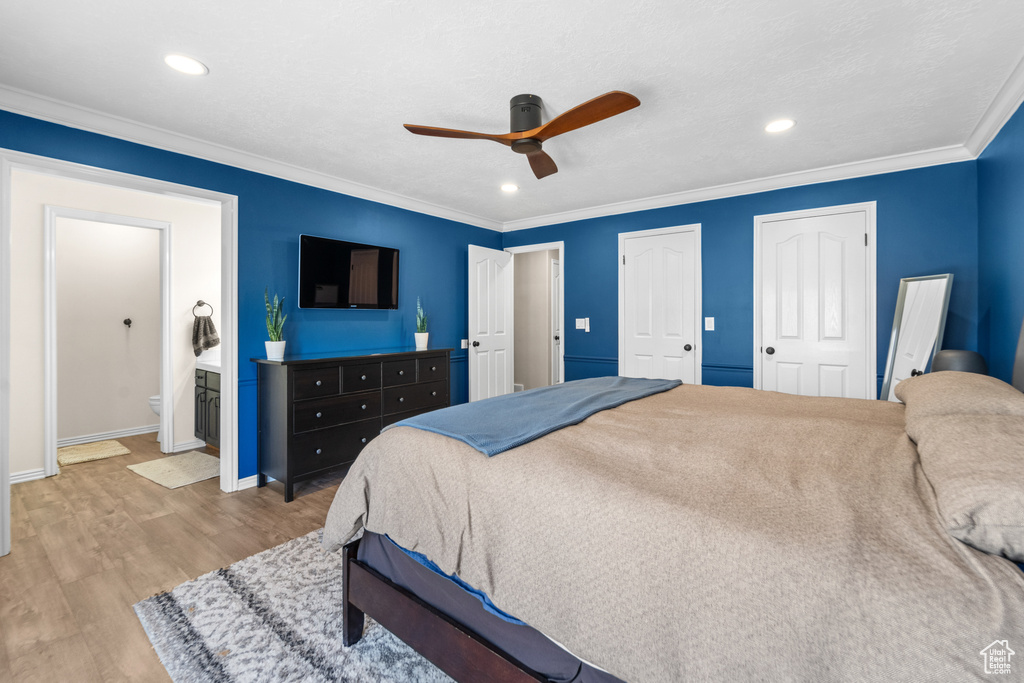 Bedroom featuring ceiling fan, crown molding, hardwood / wood-style flooring, and ensuite bath