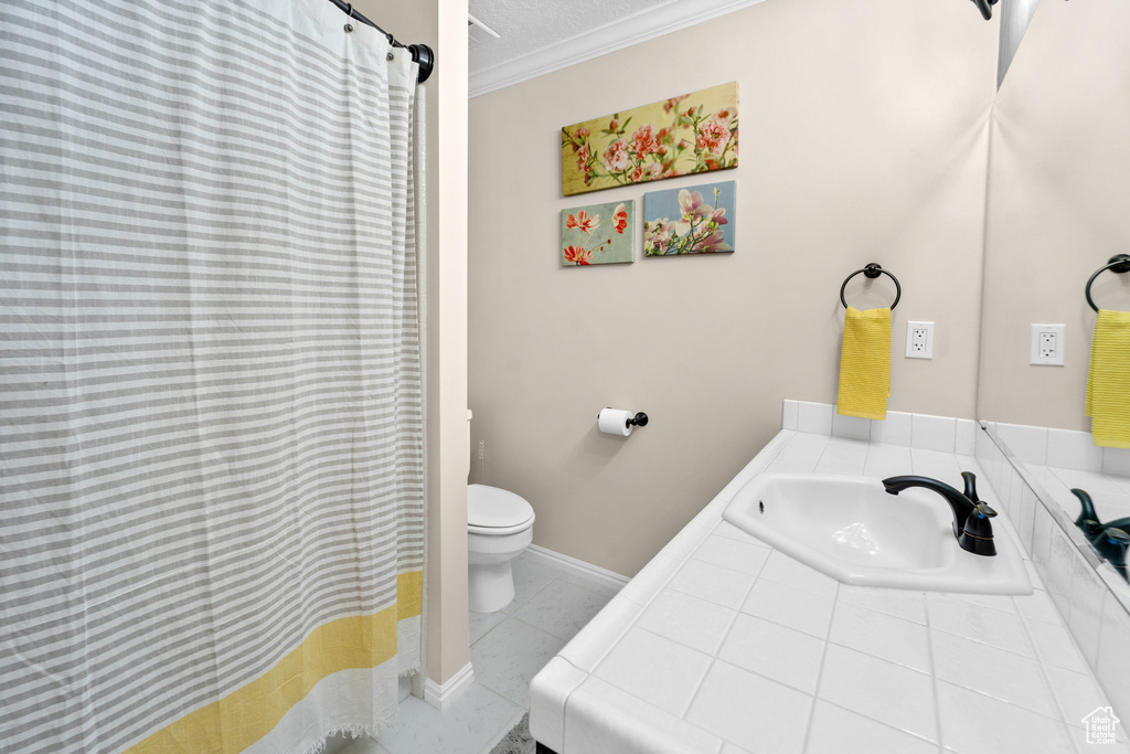 Bathroom with sink, crown molding, toilet, and tile floors