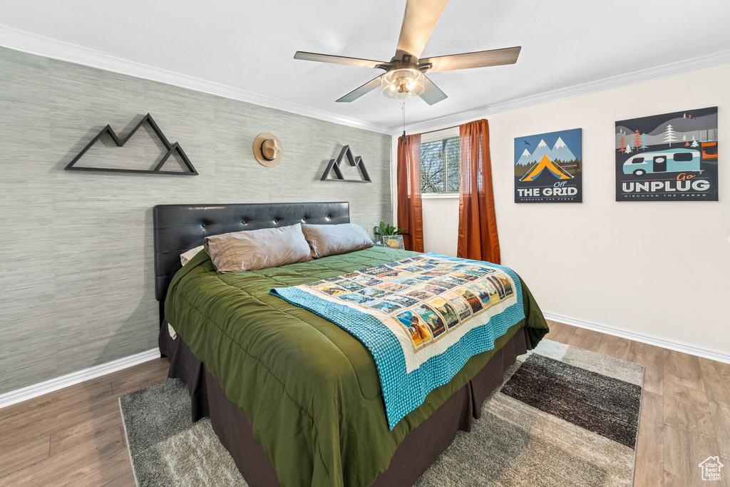 Bedroom featuring ceiling fan, ornamental molding, and dark hardwood / wood-style floors