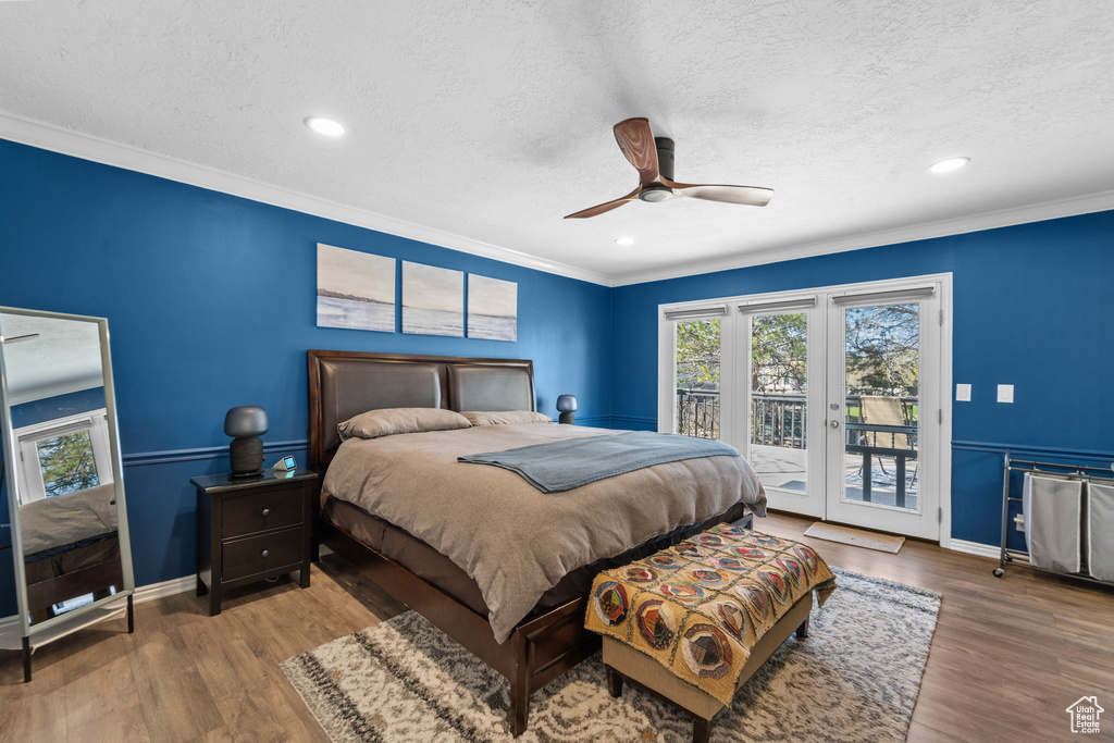 Bedroom with crown molding, dark hardwood / wood-style floors, ceiling fan, a textured ceiling, and access to outside