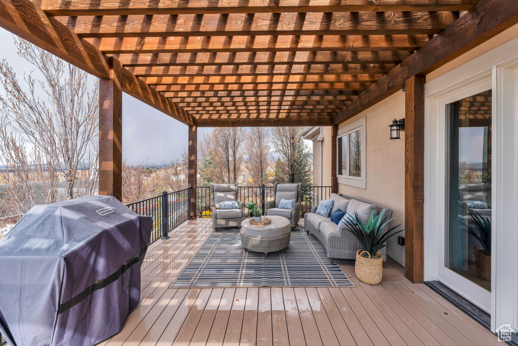 Wooden terrace featuring a grill, an outdoor living space, and a pergola