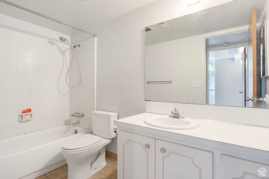 Full bathroom featuring tiled shower / bath, toilet, tile flooring, and vanity